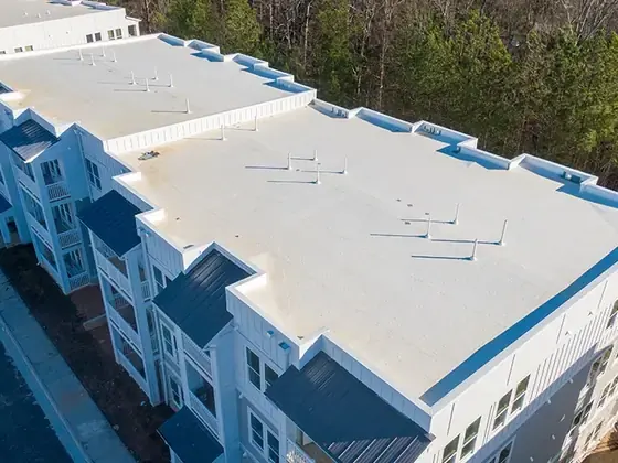 Aerial view of a long white flat roof on a multi-unit apartment building
