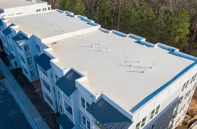Aerial view of a white flat-roofed multi-story apartment building