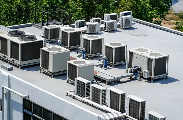 Flat commercial roof with rows of rooftop air conditioning units